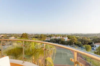 a balcony with a view of a tennis court at Sea-Stretch viewing SuperKing flat by BentoBox in Albufeira