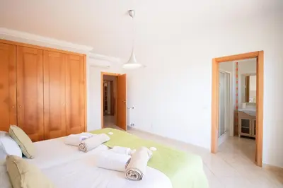a bedroom with a large white bed with towels on it at Villa Cinema - Perfect Union in Albufeira