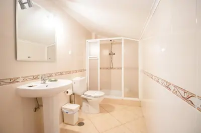 a white bathroom with a toilet and a sink at Villa Cinema - Perfect Union in Albufeira