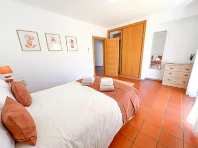 a bedroom with a white bed and a orange tile floor at Villa Mia - Peerless Bond in Albufeira