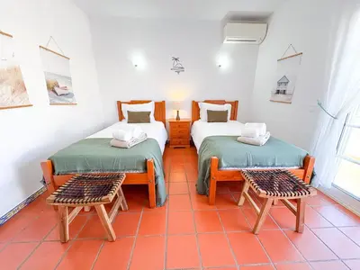 a room with two beds and two chairs in it at Villa Mia - Peerless Bond in Albufeira