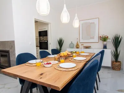 a wooden table with blue chairs and a dining room at Serenity 03 House by Stay ici Algarve Holiday Rental in Albufeira