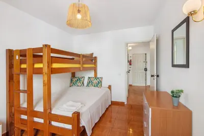 a bedroom with a bunk bed and a desk at T2 2 Linha Praia Vista Mar in Quarteira