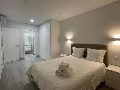 a bedroom with a bed with two stuffed animals on it at Apartamento Noronki - Altos do Forte Novo in Quarteira