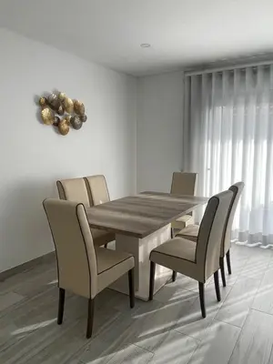 a dining room with a wooden table and chairs at Apartamento Noronki - Altos do Forte Novo in Quarteira
