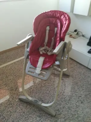 a red high chair sitting in a room at Lovely flat in the center in Faro