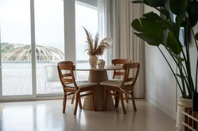 a dining room table with chairs and a vase on it at Apartamento Mare Aveiros Beach in Albufeira