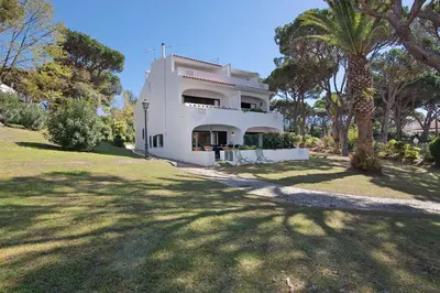a white house with trees in front of it at Celestial Blue Vale Do Lobo in Almancil