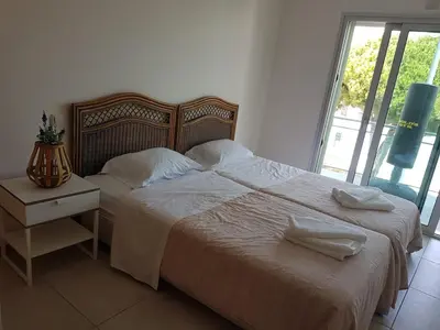 a bedroom with two beds with white sheets and a nightstand at Modern apartment on the beach of Falesia in Albufeira