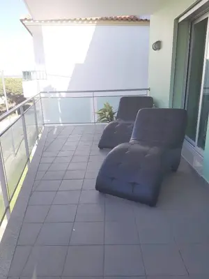 a balcony with two couches on a building at Modern apartment on the beach of Falesia in Albufeira