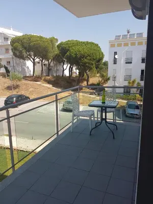 a balcony with a table and chairs and a view of a street at Modern apartment on the beach of Falesia in Albufeira