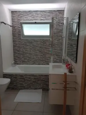 a bathroom with a tub and a sink and a window at Modern apartment on the beach of Falesia in Albufeira