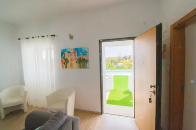 a living room with a couch and a sliding glass door at Villa Azul in Boliqueime
