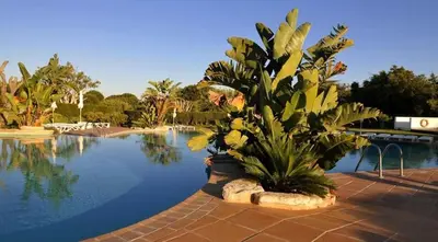 a white house with a balcony with a table and chairs at Acolhedor Apt T1, vista piscina , Balaia Golf Village in Albufeira