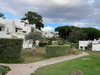 a house on a cliff next to a beach at Acolhedor Apt T1, vista piscina , Balaia Golf Village in Albufeira