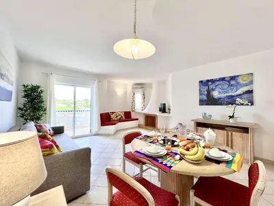 a kitchen and living room with a table and chairs at Albufeira Balaia Golf Vilage 7 With Pool by Homing in Albufeira