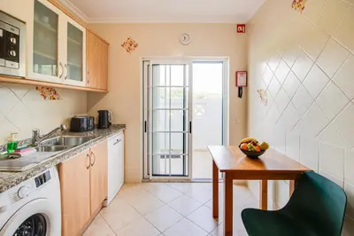 a kitchen with a table and a washing machine at Nature Escape 2BR Villa Pool Wi-Fi AC in Olhos de Água