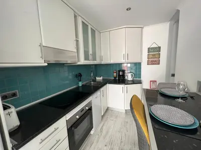 a kitchen with white cabinets and black counter tops at Casa rooftop jacuzzi and magnificent sea view in Albufeira
