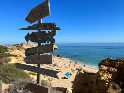 a street sign on a beach with people on the beach at Casa rooftop jacuzzi and magnificent sea view in Albufeira