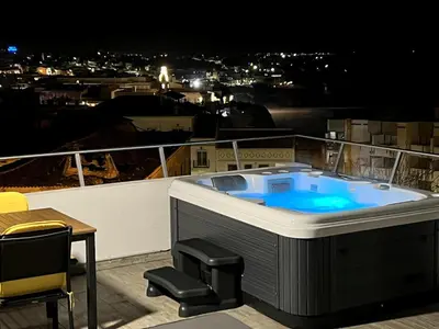 a jacuzzi tub on a balcony at night at Casa rooftop jacuzzi and magnificent sea view in Albufeira