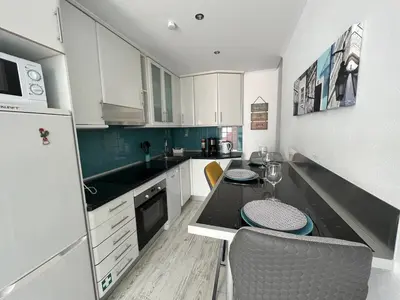 a kitchen with white cabinets and a black counter top at Casa rooftop jacuzzi and magnificent sea view in Albufeira