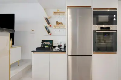 a stainless steel refrigerator in a white kitchen at Jungle Flat with Pool T2 Montechoro in Albufeira