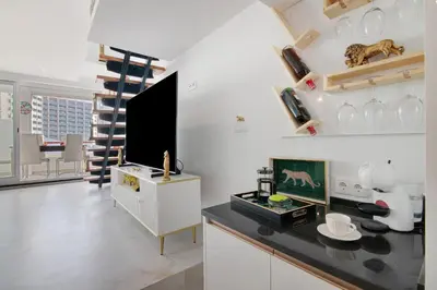 a white living room with a tv and a counter at Jungle Flat with Pool T2 Montechoro in Albufeira