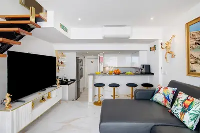 a living room with a couch and a flat screen tv at Jungle Flat with Pool T2 Montechoro in Albufeira