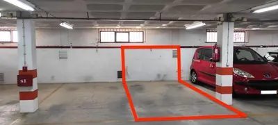 a red car parked in a parking garage at Brigida's Flat in Faro