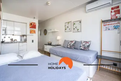 two beds in a small room with a kitchen and a room with two bedshooting at #255 Oura Cilla by Home Holidays in Albufeira