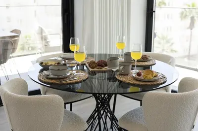 a glass table with food and glasses of wine at Terracos de Quarteira II White by Real Properties in Cavacos