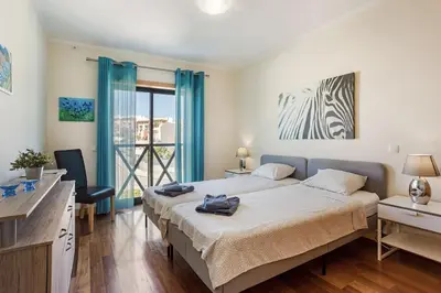 a bedroom with two beds and a balcony at Casa Peva in Albufeira