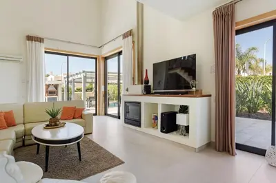 a living room with a couch and a tv at Casa Peva in Albufeira