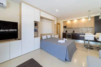 a large bedroom with a bed and a kitchen at Medronheira - Apt 1A by HelloVacations in Albufeira