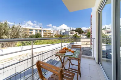a balcony with a table and chairs on a balcony at Medronheira - Apt 1A by HelloVacations in Albufeira