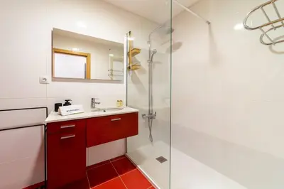 a bathroom with a shower and a sink and a mirror at Medronheira - Apt 1A by HelloVacations in Albufeira