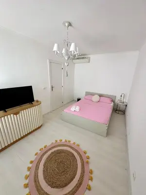 a bedroom with a pink bed and a large rug at Vilamoura Modern House in Quarteira