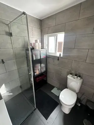 a bathroom with a toilet and a glass shower at Vilamoura Modern House in Quarteira