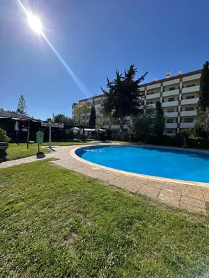 a swimming pool in a park with a building at Vilamoura Modern House in Quarteira