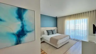 a bedroom with a bed and a large painting on the wall at Orange Boutique Residence - Casa Farol Adults Only in Quarteira
