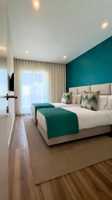 a large bedroom with two beds and a blue wall at Orange Boutique Residence - Casa Farol Adults Only in Quarteira