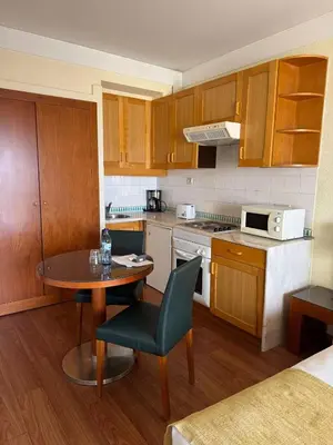 a kitchen with wooden cabinets and a table and chairs at Hotel Vila Galé Cerro Alagoa in Albufeira