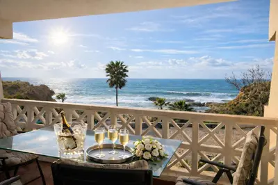 a table with wine glasses and a view of the ocean at Ocean Bliss - Panoramic Sea View - 20m to Beach - 2 Swimming Pools - Private Parking in Albufeira