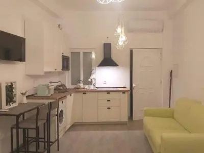 a kitchen with a couch and a table in a room at House e Beach in Albufeira