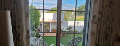 a window with two chairs and a view of a yard at Albufeira Home Paderne in Paderne