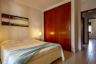a bedroom with a large bed and a red door at Apartamento Laurus in Albufeira