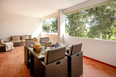 a living room with a table and chairs and a large window at Apartamento Laurus in Albufeira