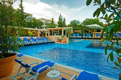 a large swimming pool with blue chairs in a resort at Apartamento Laurus in Albufeira