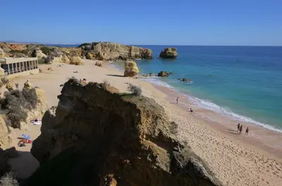 a beach with people on the sand and the water at Villa Ana in Albufeira