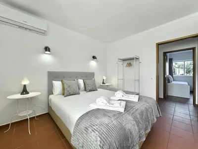 a bedroom with a bed with towels on it at Beach 15 min away! - Rustic with AC and WiFi in Quarteira